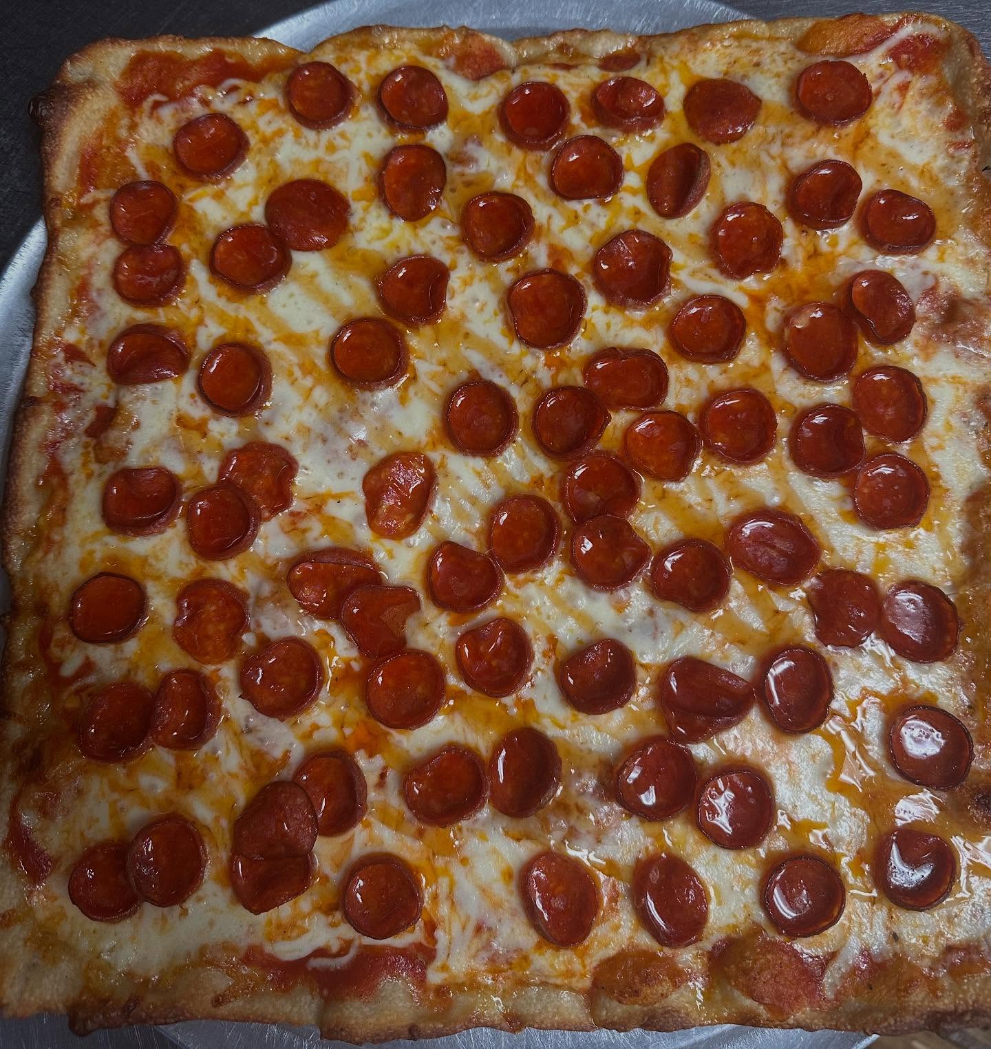 Square pepperoni pie with cup and char pepperoni at Carlo's